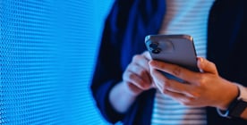 person-holding-phone-276x140